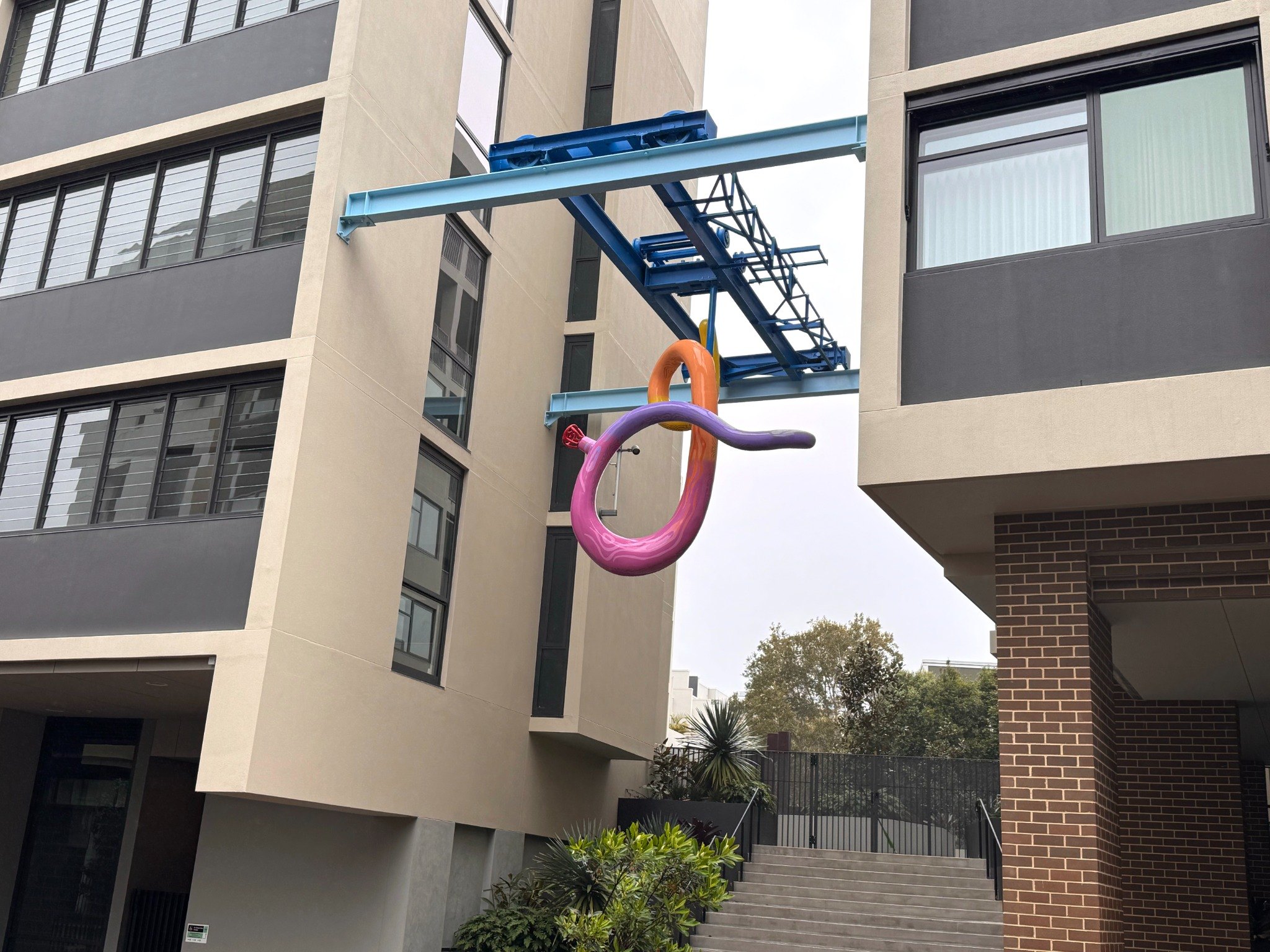 Colourful suspended sculpture between apartment buildings on Ralph Street, Alexandria
