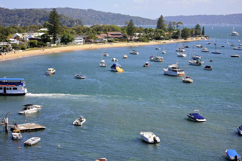 Moored boats off the Bayview foreshore on Pittwater, with houses along the beach