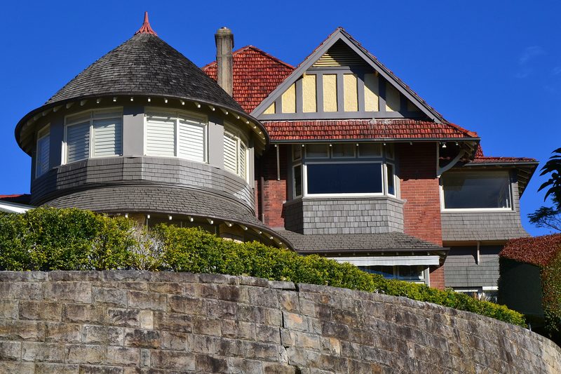 A Federation house with a turret roof above a sandstone retaining wall, Bellevue Hill