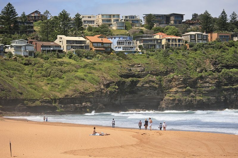 Houses stepping up the headland above the sand at Bilgola Beach