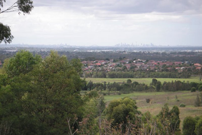 Bossley Park rooftops seen from the Western Sydney Parklands lookout, with the city skyline on the horizon