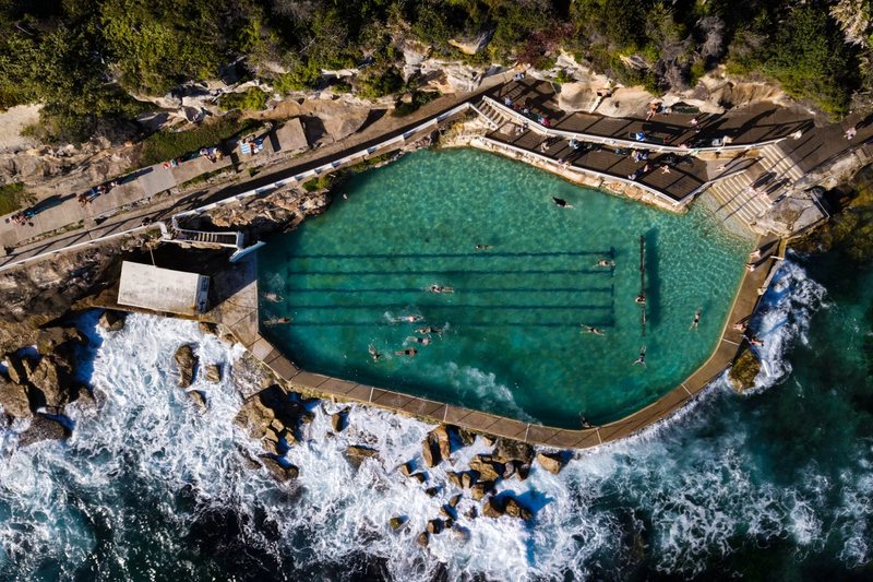 Aerial view of the Bronte Baths ocean pool on the rock shelf, with surf breaking alongside