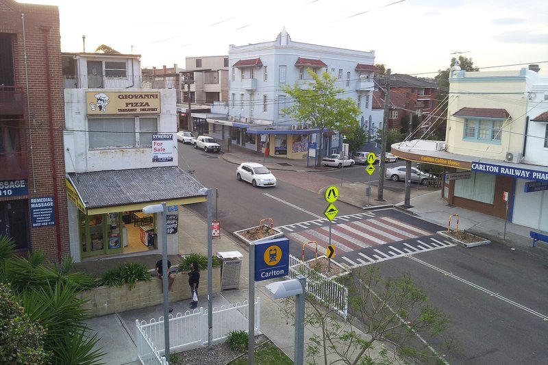 Shops and flats around the crossing at Carlton station