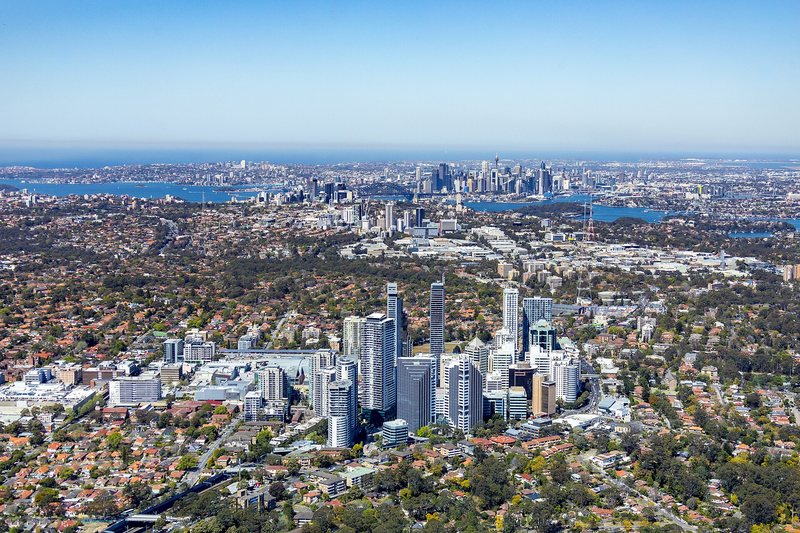 Aerial view over the Chatswood town centre towers, with the city in the distance