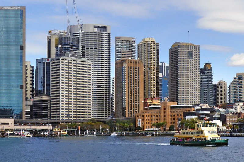 Circular Quay and the Sydney CBD skyline seen from the harbour, with a ferry crossing