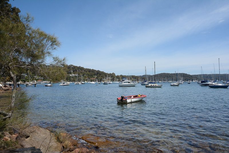 Moored boats on Pittwater seen from the rocky shore at Clareville