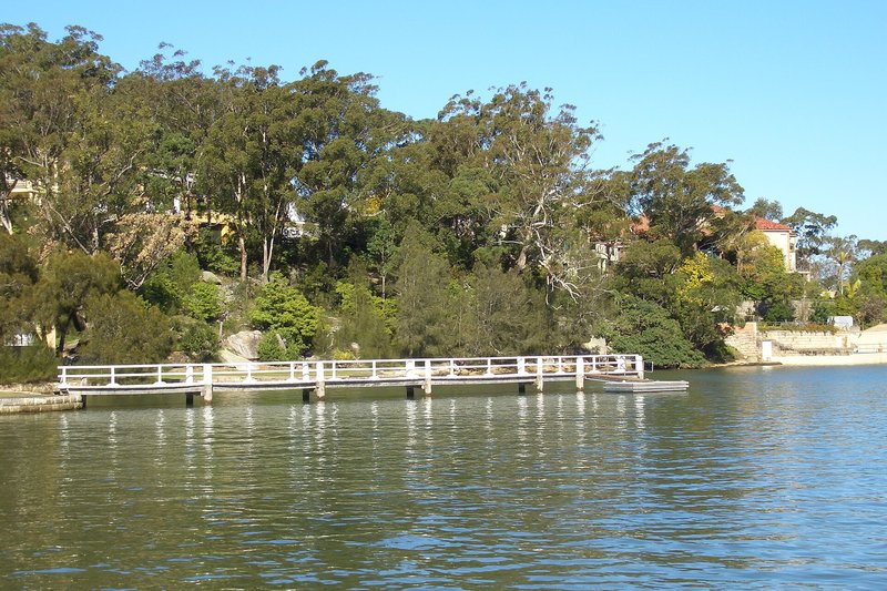 The sailing club wharf reaching out from the wooded shore at Connells Point