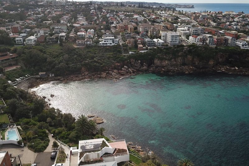 Aerial view over Gordons Bay at Coogee, with houses along the clifftop above the water
