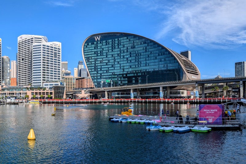 Cockle Bay at Darling Harbour, with pedal boats moored below the curved glass of the W hotel