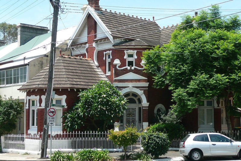 An ornate Victorian brick house with a corner turret and palisade fence on London Street, Enmore