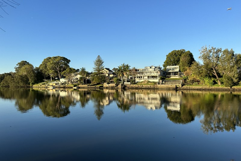 Houses along the Georges River at Georges Hall, reflected in still water