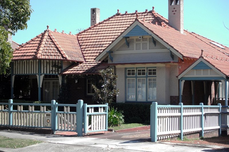 A Federation bungalow with a tiled roof, gabled porch and picket fence on Rogers Street, Haberfield