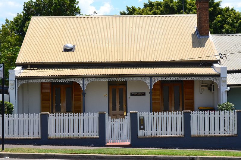 A single storey cottage with iron lace verandah and picket fence on Harris Street, Harris Park