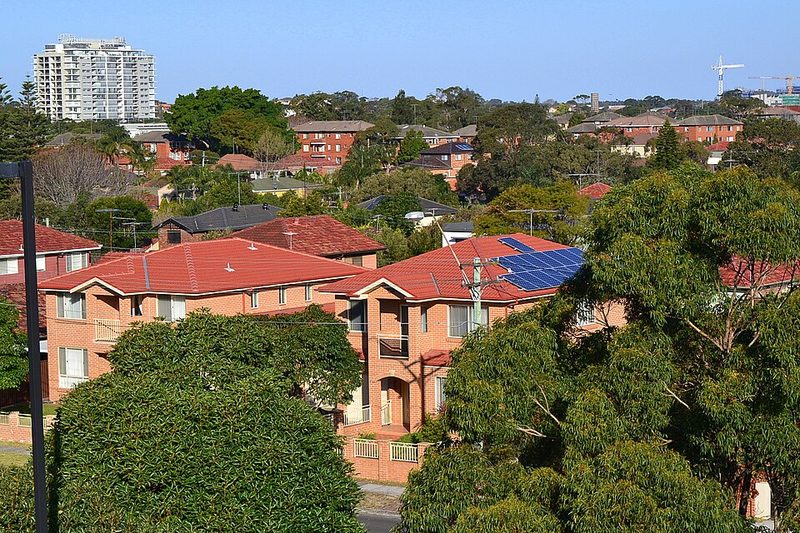 Rooftops of red-brick walk-up flats and houses across Hillsdale