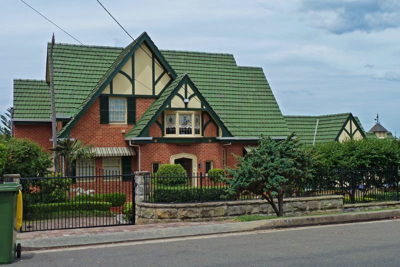 A substantial brick and tile home behind a sandstone wall on a Kangaroo Point street