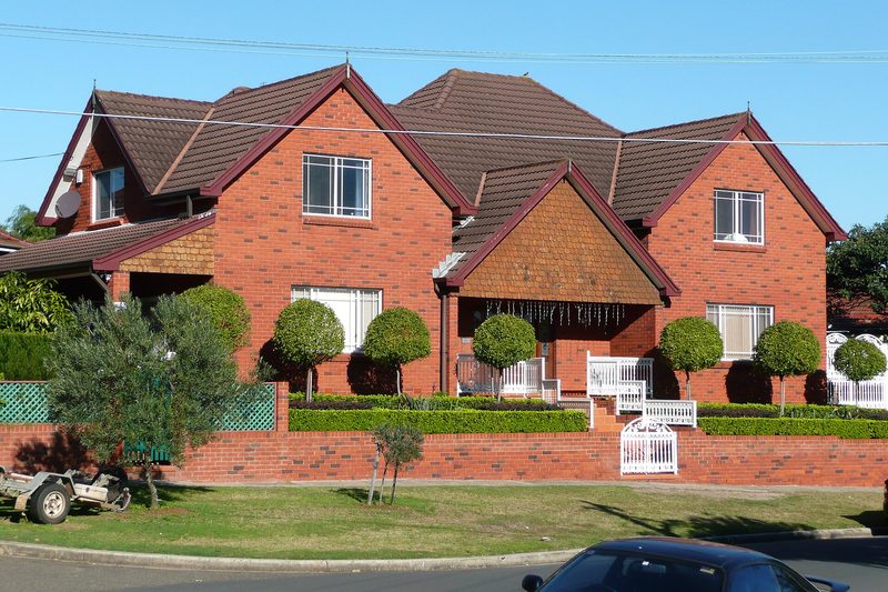 Red-brick house behind a clipped hedge on a Kingsford street
