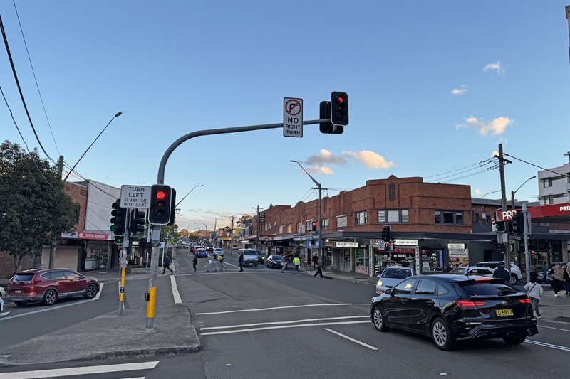 The intersection and shopfronts on Kingsgrove Road at dusk