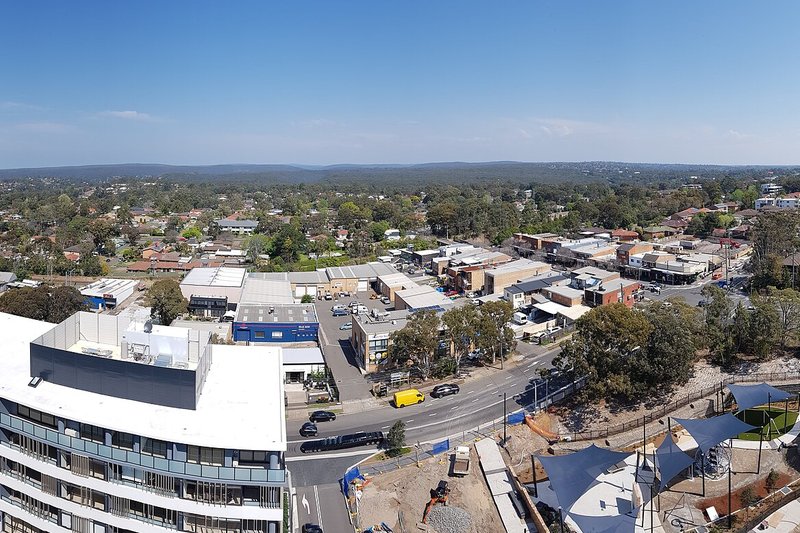 Elevated view over the Kirrawee shops and rooftops toward the bushland horizon