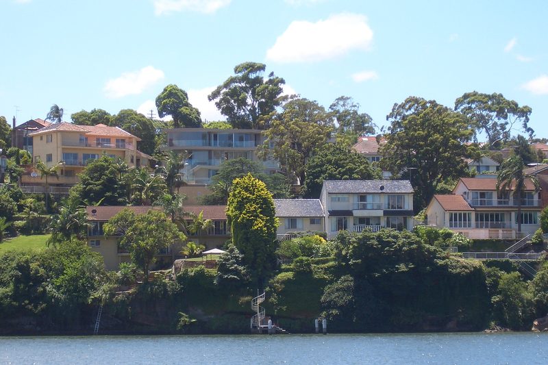Houses stepping down the wooded slope to the river at Linley Point