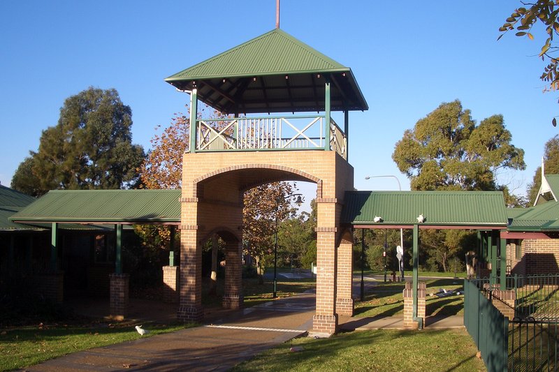 The brick and green-roofed community buildings and bell tower at Menai