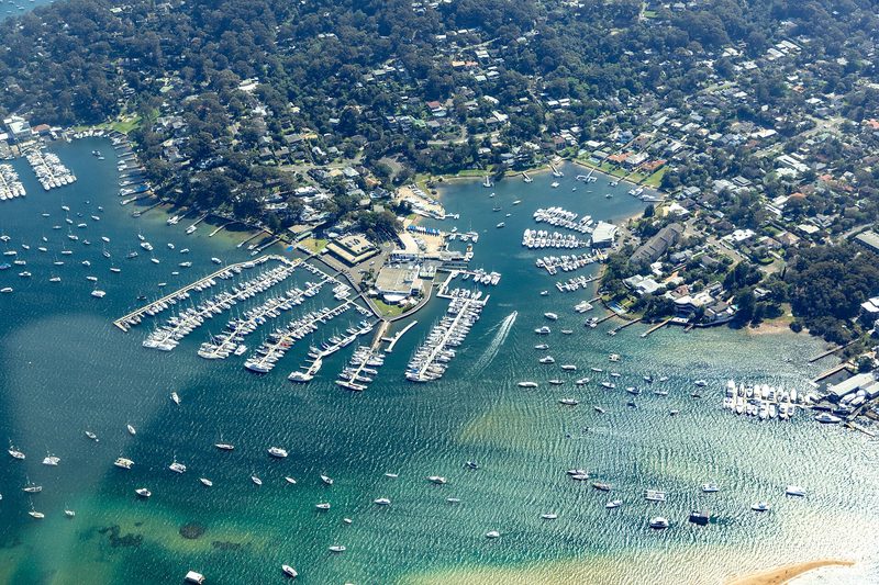 Newport from the air, houses among the trees above the Pittwater marina