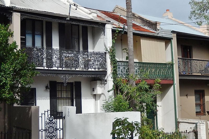 Two storey terraces with ornate iron lace balconies on a Newtown street