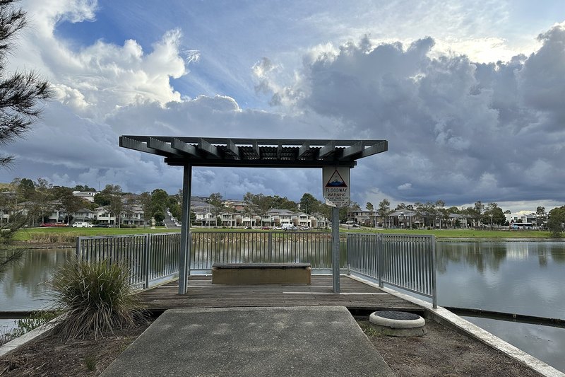Driftway Reserve in Pemulwuy, a shelter and pond with new two storey homes beyond