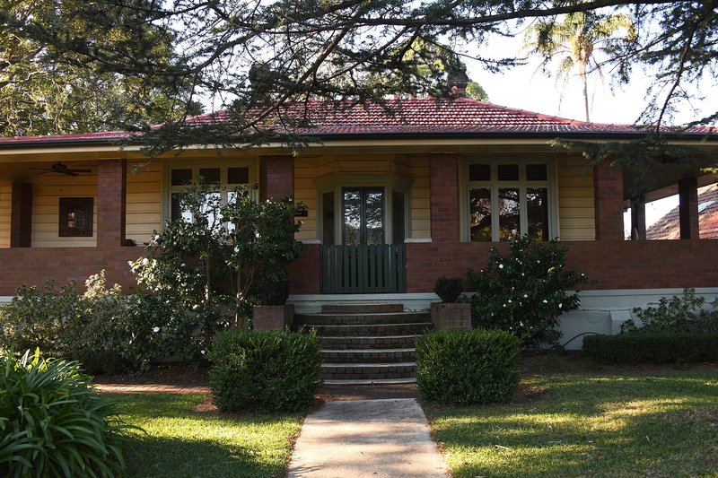 A Federation bungalow with a wide verandah and camellias in the front garden at Pennant Hills
