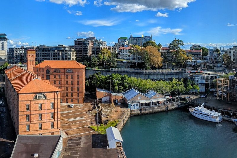 Red-brick woolstores on the Pyrmont waterfront, with apartments on the ridge behind