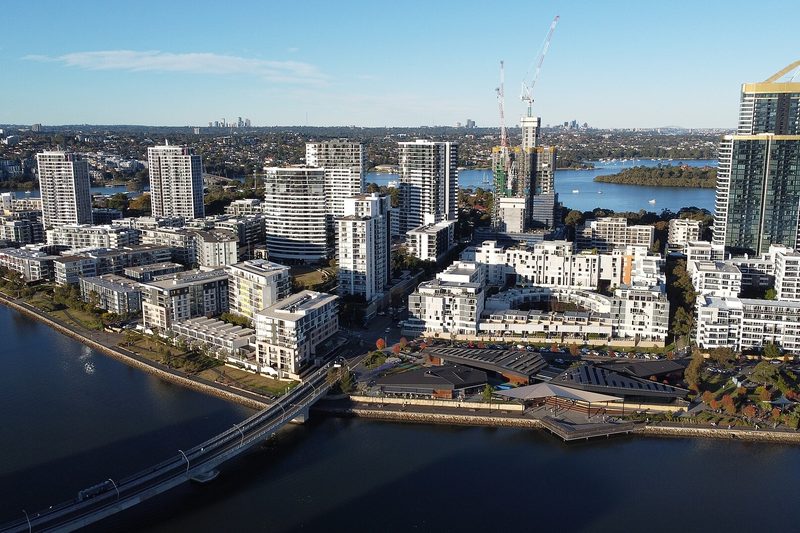 Aerial view of the Rhodes waterfront apartment towers and the rail bridge over the Parramatta River