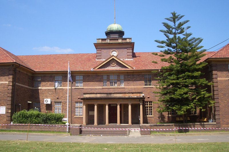The former theological college, a brick building with a clock tower and copper dome, Strathfield South