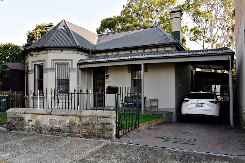 An Italianate cottage with a bay window and sandstone front wall in Sydenham