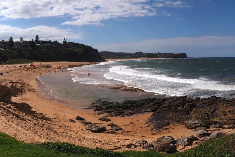 Warriewood Beach with houses along the headland above the sand